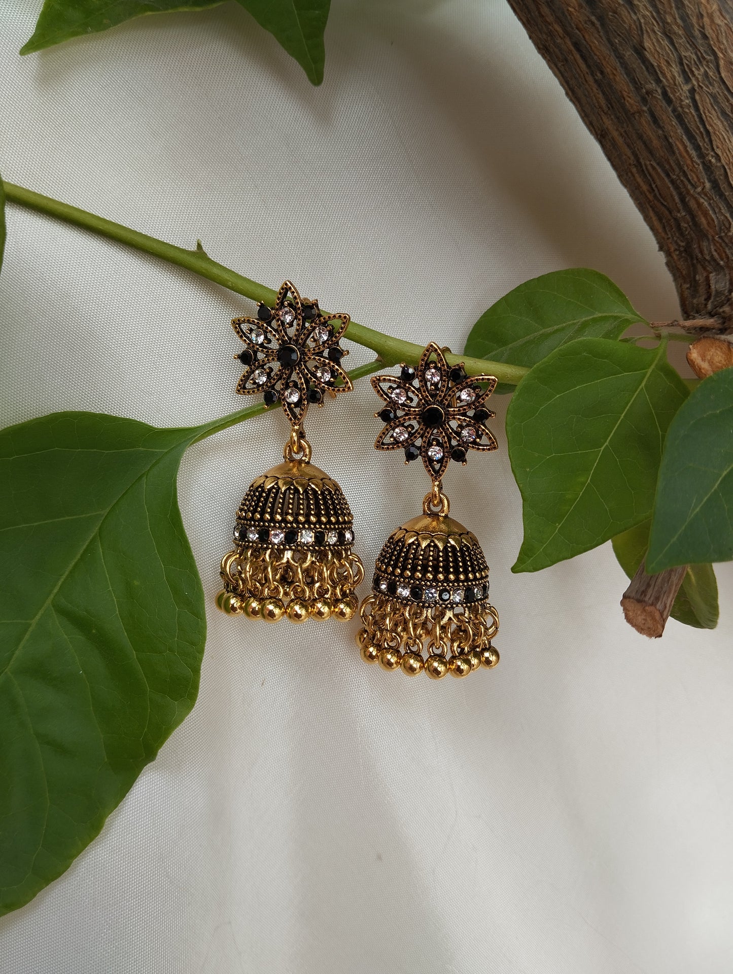 Black & White Stone Antique Gold Plated Jhumka EarringsDesign: Floral star stud + textured dome with layered ghungroos